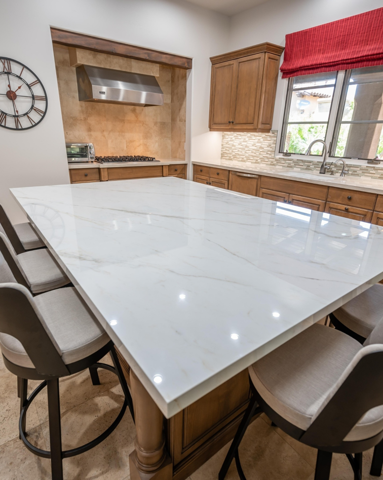 A spacious kitchen island featuring a pristine white marble or granite countertop installed by Accent Marble & Granite, Inc in Phoenix, AZ