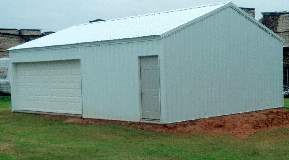 A white metal garage with a white garage door and a side entry door, completed by D.H. Construction in Jackson, TN.