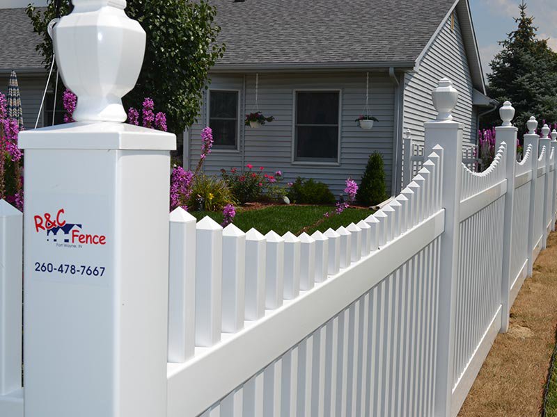 A classic white picket fence installed around a residential property by R & C Fence in Fort Wayne, IN.