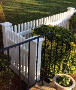 A section of white picket fence complementing a black metal railing, installed by Fence Factory Inc in Stamford, CT