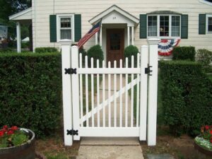 A charming white picket gate installed in a front yard by Fence Factory Inc, providing curb appeal in Stamford, CT