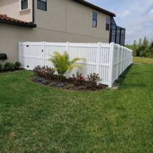 A classic white picket-style vinyl fence installed around a residential yard by Keeler Fence in New Port Richey, FL.