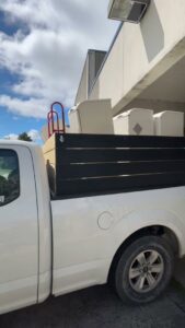A white pickup truck loaded with furniture and other items for junk removal by Indy Trash Guy in Fishers, IN.