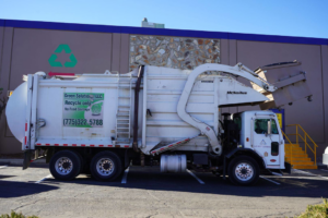 A white recycling collection truck with Green Solutions Recycling branding parked in Reno, NV.