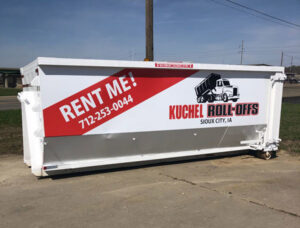 A white roll-off dumpster with 'RENT ME!' branding from Kuchel Roll-Offs in Sioux City, IA.