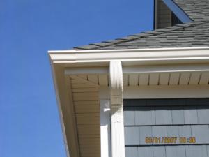Newly installed white seamless gutter and downspout on a house by Flow Masterz Seamless Gutters in Wilmington, NC.