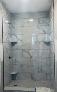 White marble-look tiles being installed in a shower by Kizer Construction in Owensboro, KY.