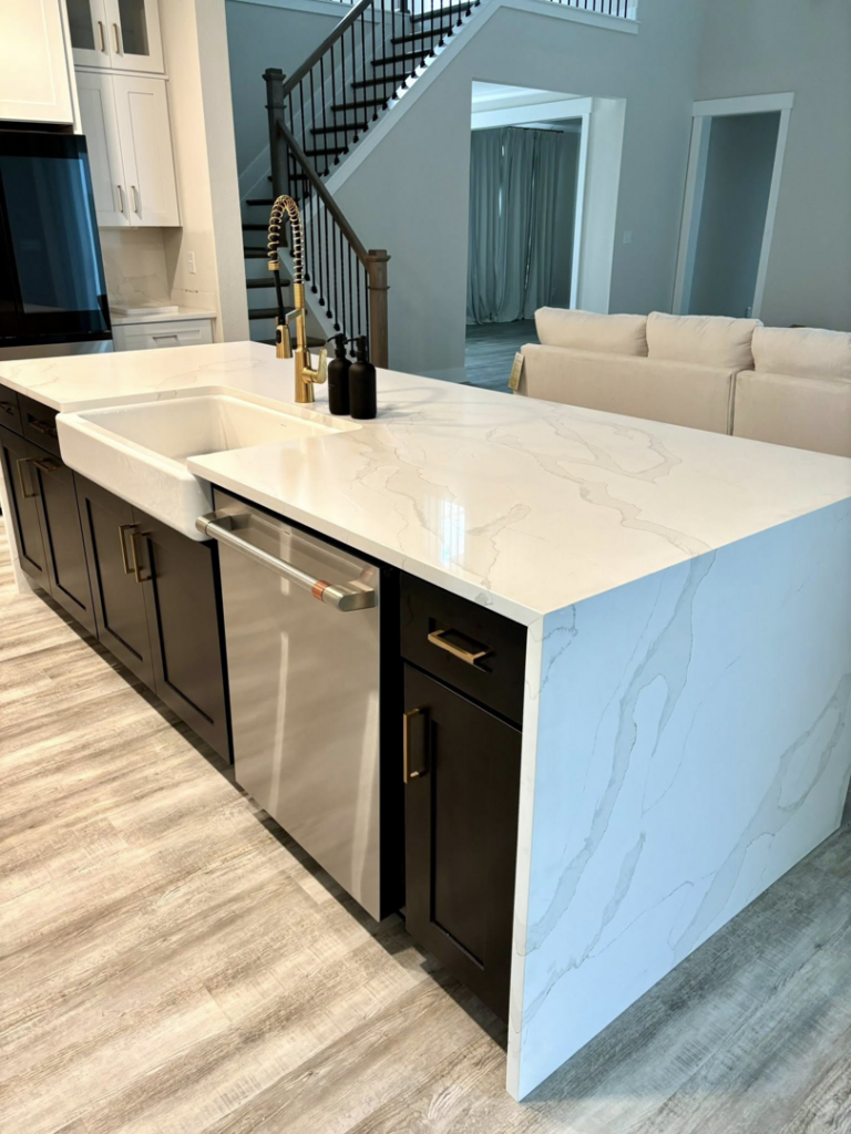 Elegant white stone kitchen island countertop with an integrated farmhouse sink by Dream Stone Countertops in Norfolk, VA