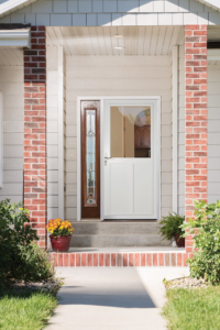 A white storm door with a solid bottom panel and decorative glass main door, installed by Denver Storm Door in Denver, CO.