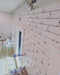 White subway tile installation in progress on a wall by Nation / Phillips Construction in Tacoma, WA.