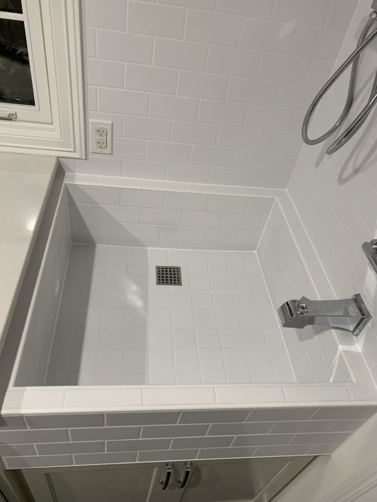 A white tiled utility sink or dog wash station installed by Andalex Construction LLC in Gresham, OR.