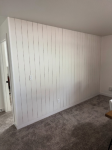 A newly installed white vertical shiplap accent wall by LIV Custom Accents in West Fargo, ND