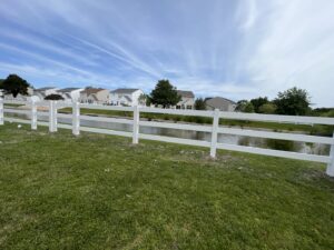 Newly installed white vinyl fence along a waterfront property by BOS HOME Exterior Services in Virginia Beach, VA