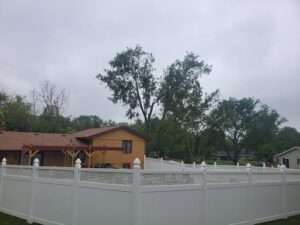 A white vinyl fence with a lattice top installed around a backyard by Badger Vinyl Products in Madison, WI.