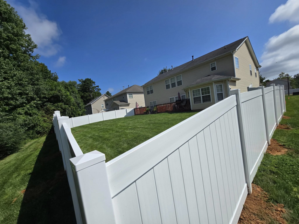 A newly installed white vinyl privacy fence enclosing a residential backyard by S&L Decking and Fencing in Charlotte, NC.