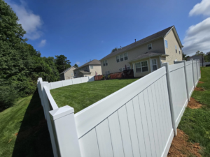 A newly installed white vinyl privacy fence enclosing a residential backyard by S&L Decking and Fencing in Charlotte, NC.