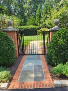 A newly installed white vinyl privacy fence next to a green bush by Minors Fences in Ashland, VA.