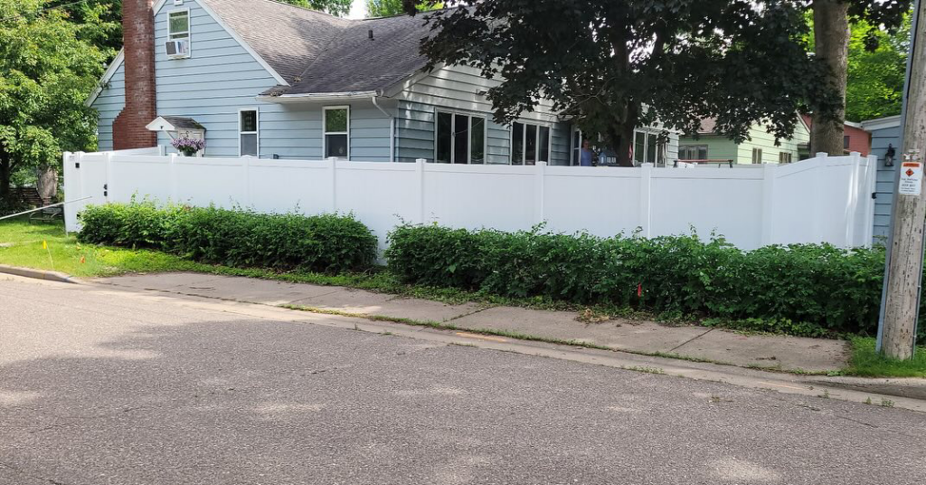 A white vinyl privacy fence installed along a street for a home by Cyclone Fence in Somerset, WI.