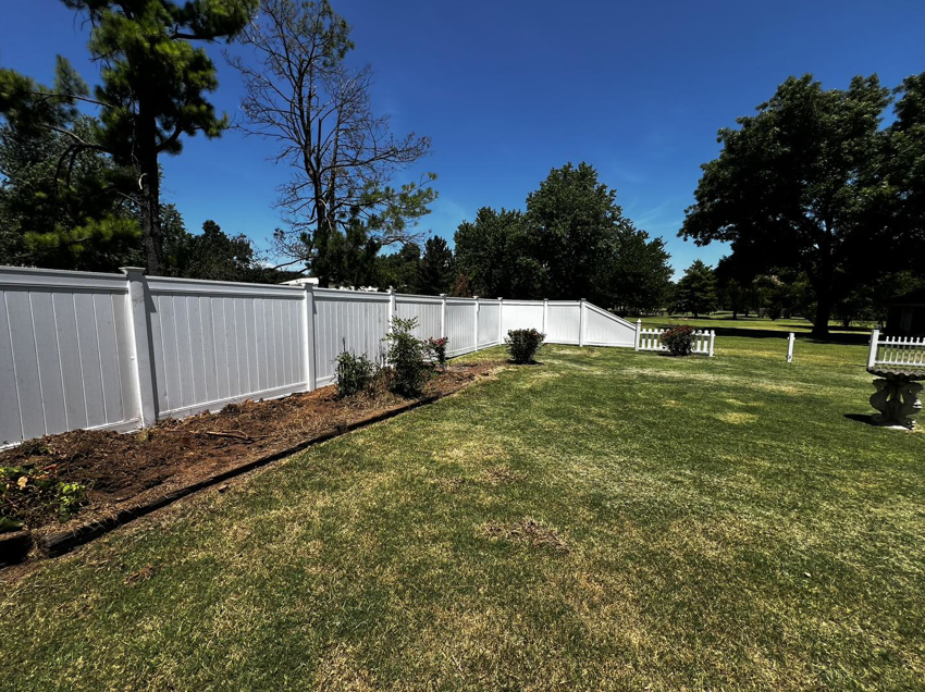 A new white vinyl privacy fence installed in a residential backyard by Herron Fencing LLC in Shawnee, OK.