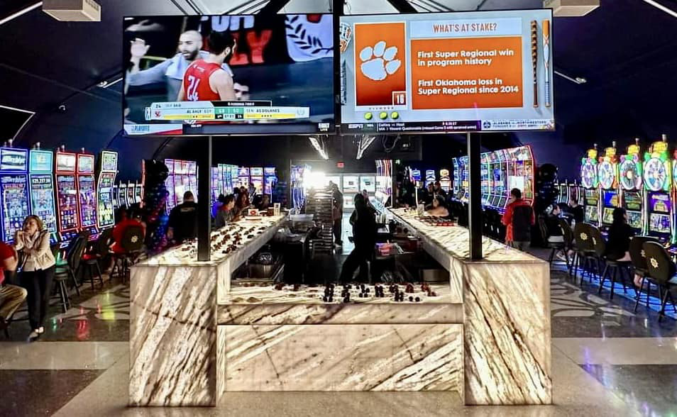 A wide view of a completed commercial bar area with large screens, showcasing a successful general contractor project by COMAF Marble & Granite in El Paso, TX.