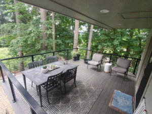A wide view of a modern deck featuring cable railings, dining, and lounge furniture, completed by Edge River Home Services in Springfield, OR.