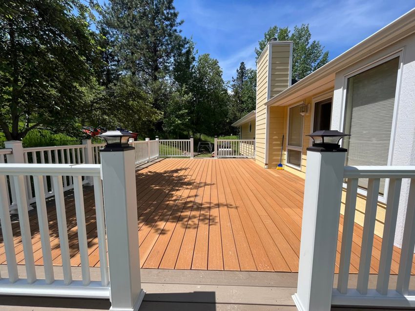 A wide view of a newly built outdoor deck with white railings by Royal Construction & Remodeling, Inc. in Lake Charles, LA.