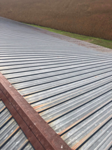 A wide view of a rusty metal roof requiring maintenance from Extreme Precision Painting in Elizabethtown, KY.