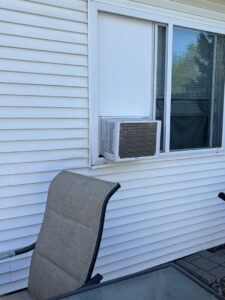 A window air conditioning unit professionally installed in a window of a house by Amazing Handyman Services in West Fargo, ND