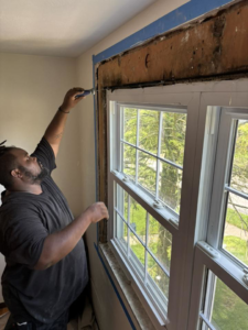 A contractor carefully removing window casing during a renovation project by Ridgely Home Services LLC in Pittsburgh, PA.