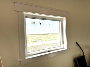 A newly installed window with fresh white trim by Northeast SD Handyman in Watertown, SD.