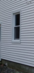 A newly installed white window and siding on a house by Class General Contracting in West Springfield, MA.
