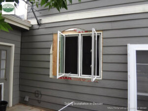 Window and siding installation in progress on a house by Colorado Window Solutions in Denver, CO.