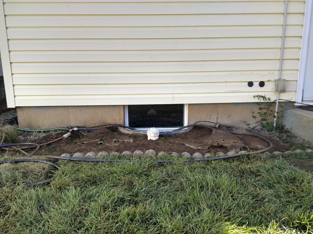 Excavation work for a window well or drainage system next to a house foundation by Aspen Excavation in Spokane, WA.