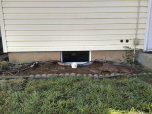 Excavation work for a window well or drainage system next to a house foundation by Aspen Excavation in Spokane, WA.