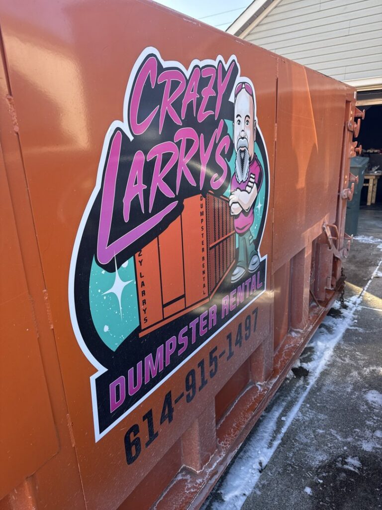 An empty orange dumpster from Crazy Larry's Dumpster Rental placed in a snowy residential driveway in Columbus, OH.