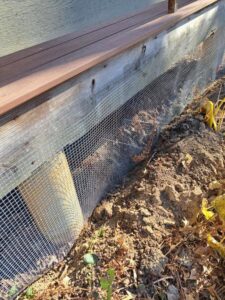 Wire mesh installed as skirting along the base of a wooden deck, providing pest control or aesthetic finishing by JAMS Property Preservation LLC in Dayton, OH.