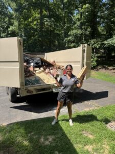 A Dumpzilla team member loading bricks and construction debris into a dump trailer in Raleigh, NC.
