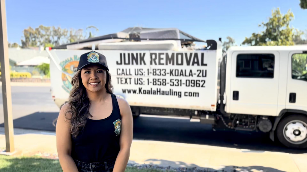 A Koala Hauling team member stands proudly in front of their junk removal truck with items in the bed in San Diego, CA.