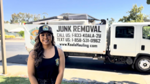 A Koala Hauling team member stands proudly in front of their junk removal truck with items in the bed in San Diego, CA.
