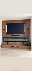 A modern living room featuring a custom wood accent wall with integrated TV and electric fireplace by Wareham Home Improvements in Frederick, MD.