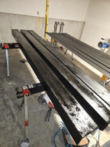 Wood beams being stained for a home renovation project by This and That Handyman and Home Wellness in Olathe, KS.