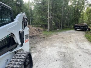 Wood chip and debris removal with a skid steer and dump trailer by A&A Property Renovations LLC in Green Bay, WI.