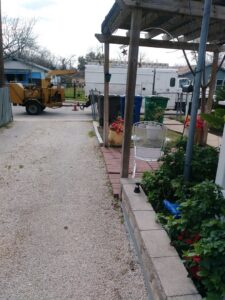 A yellow wood chipper machine used for debris removal by Suarez Tree Service in San Antonio, TX.