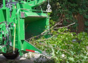 A wood chipper actively processing tree branches for debris removal by Pittsburgh Tree Trimming & Removal Service in Pittsburgh, PA.