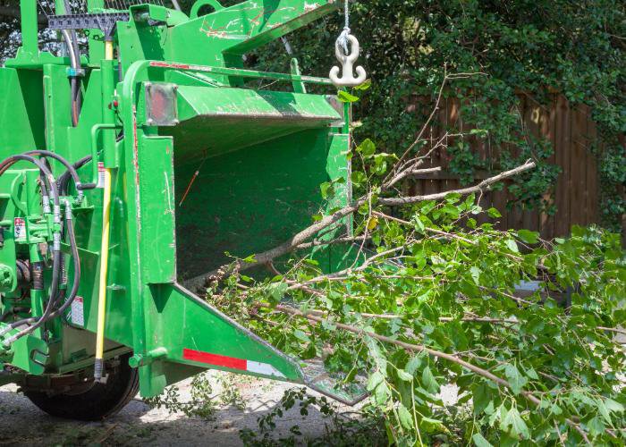A wood chipper actively processing tree branches for debris removal by Pittsburgh Tree Trimming & Removal Service in Pittsburgh, PA.