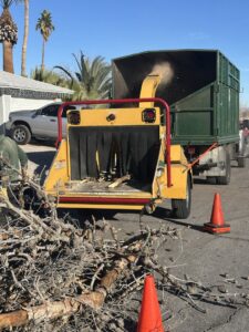 A powerful wood chipper in action, processing tree branches after a tree service job by Rocky's Tree Service in Las Vegas, NV.