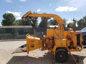A large yellow wood chipper machine used by Tapson's Tree Service in Boise, ID, for processing tree debris.