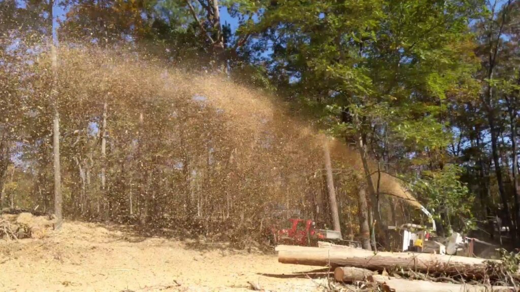 A wood chipper actively processing tree branches and debris during a tree service job for Lumberjacks Tree Service in Chattanooga, TN.