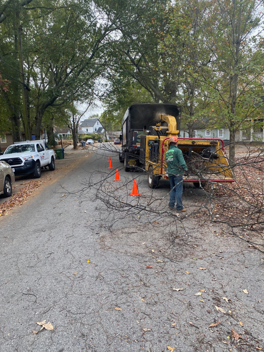 A tree service worker operating a wood chipper to clear branches for Smiles Tree Service in Atlanta, GA.