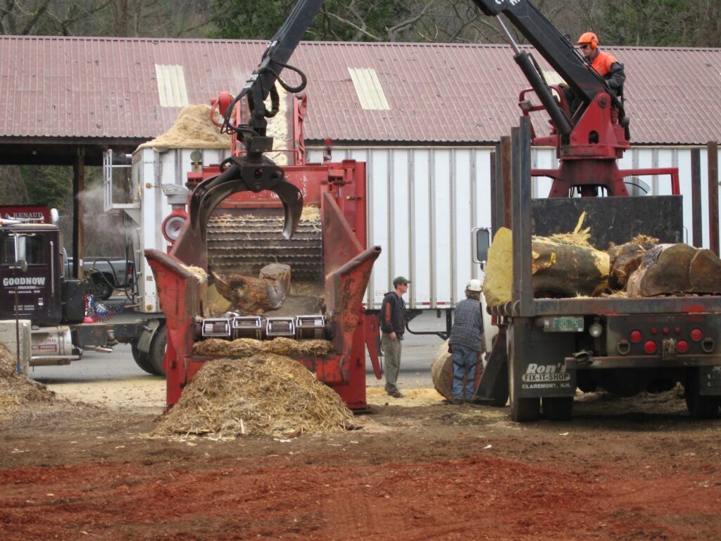 A large wood chipper processing tree debris into mulch at Renaud Tree Care in Dummerston, VT